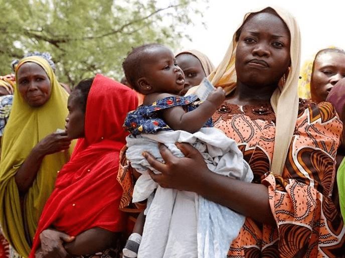 A mother holding her infant at a community health gathering