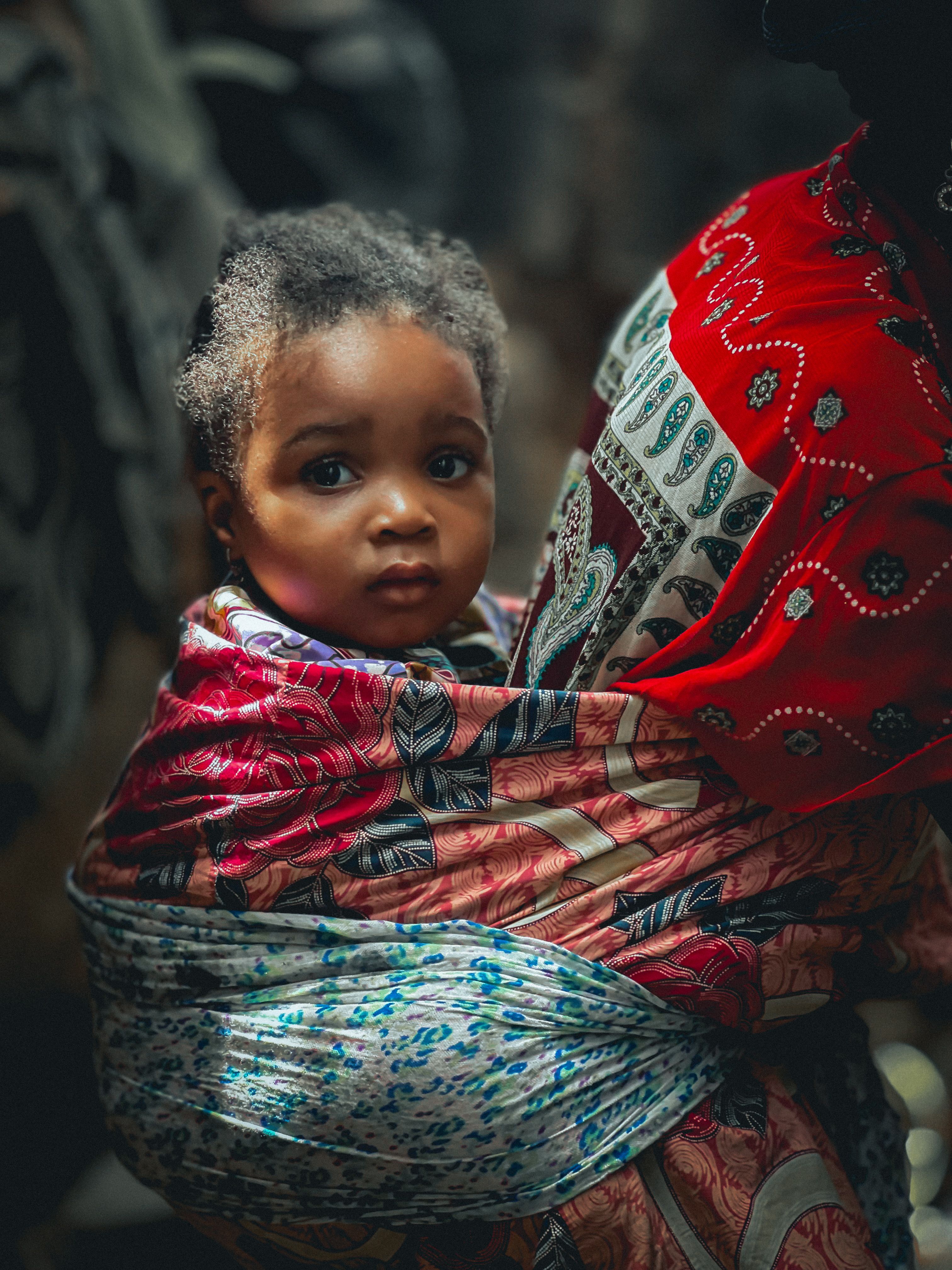 A mother holding her infant at a community health gathering